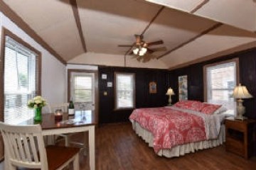 a bedroom with a bed and a chair in a room