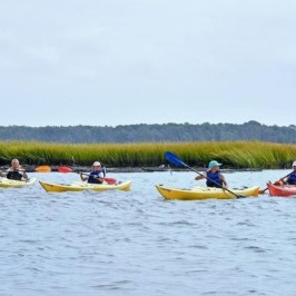 a group of people in a small boat in a body of water