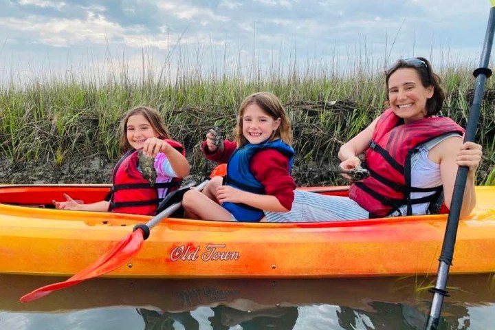 a small child smiling in front of a body of water