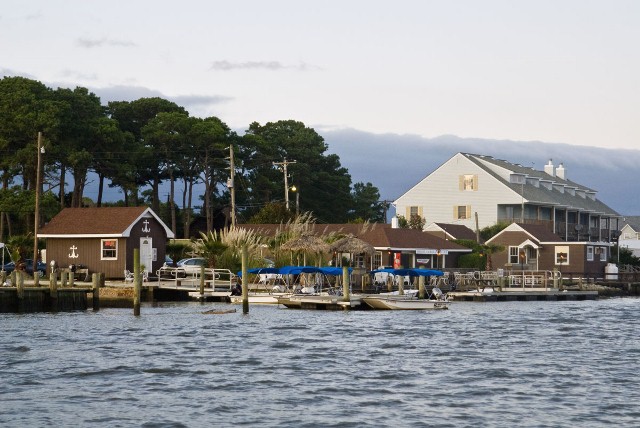 a small boat in a body of water in front of a house