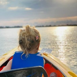a person sitting in a boat on a body of water